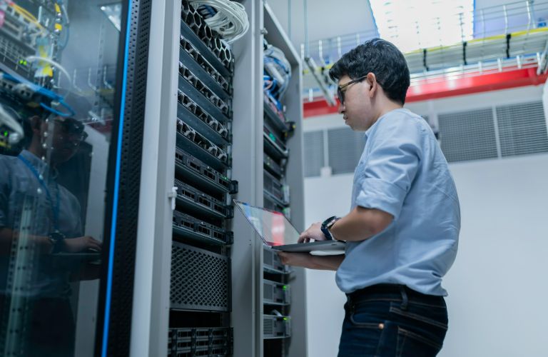 Man working in a data center with laptop
