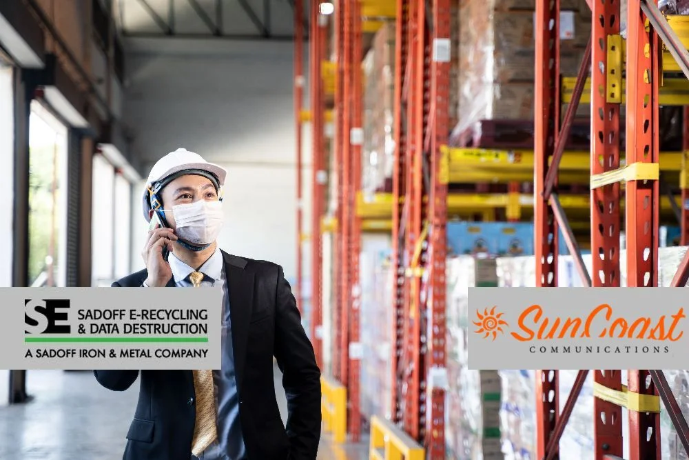 Man looking through a telecom warehouse with Sadoff and SunCoast logos