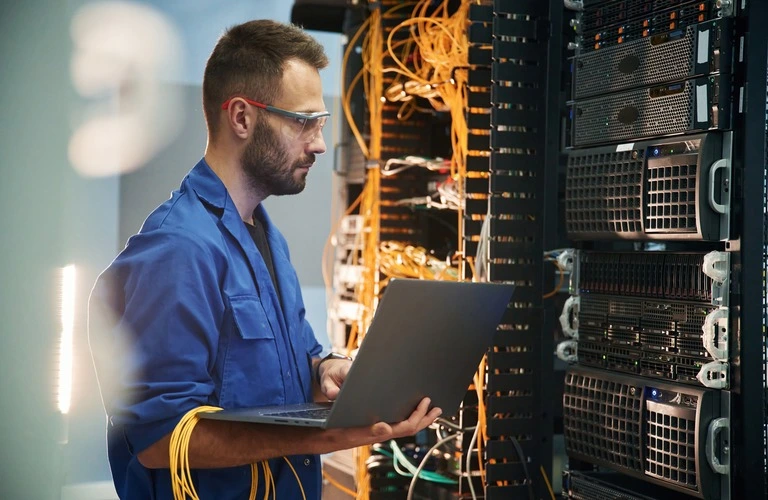 engineer with laptop in server room